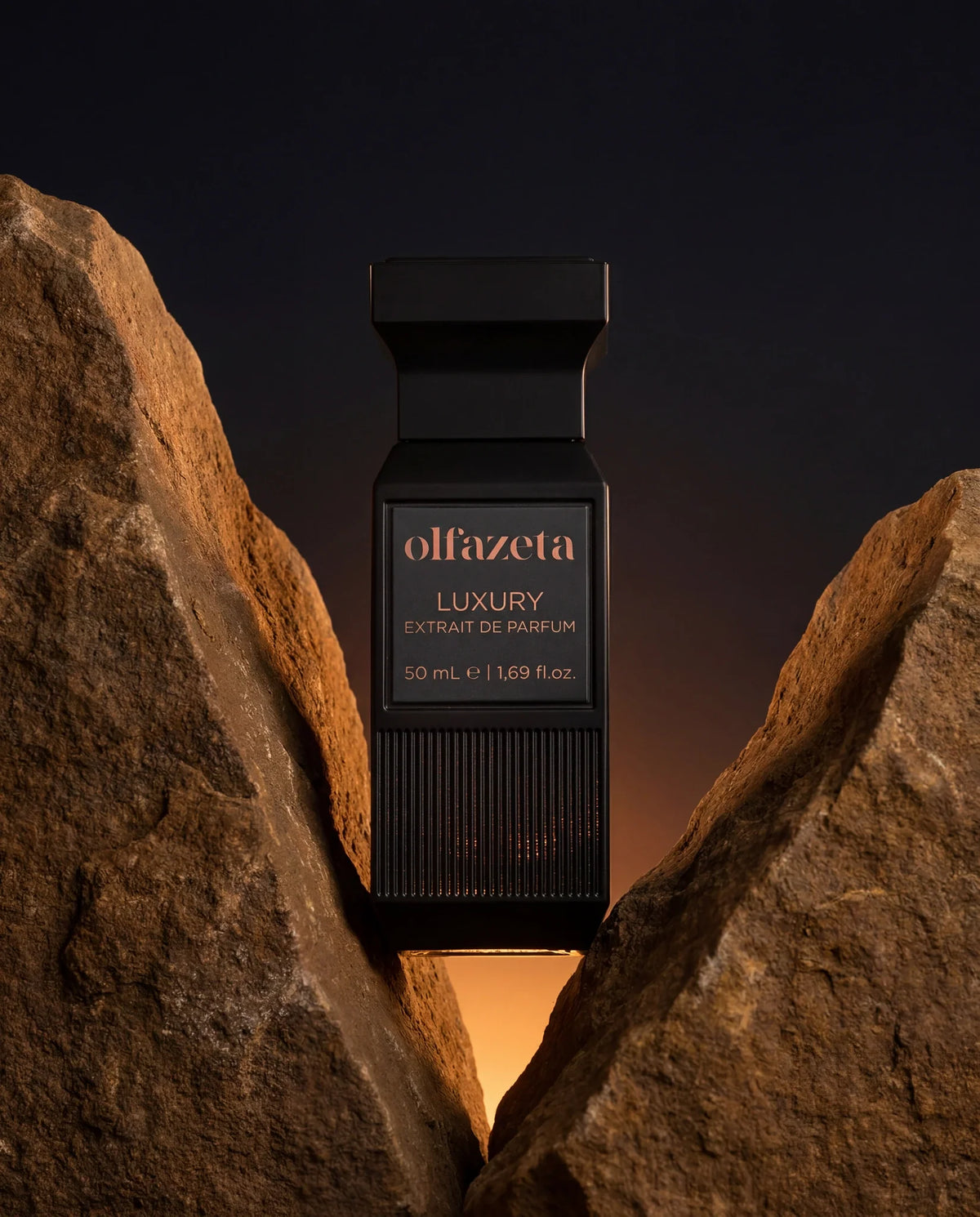 Zwarte Olfazeta by Chogan Luxury N°74 flacon tussen twee okerkleurige rotsen bij zonsondergang